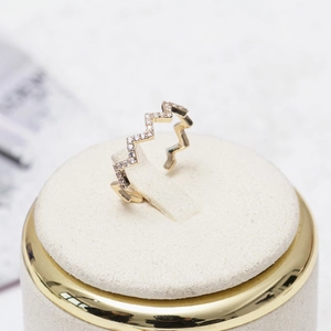Detailed view of gold wave ring with micro-pave zircons and geometric zigzag design