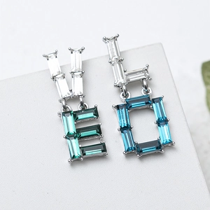 Asymmetric LOVE earrings with colorful crystals and rectangular cut on white surface