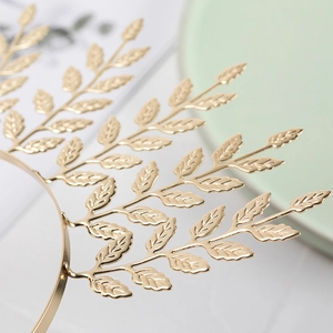 Detail of a golden leaf bridal headband featuring intricate textures and a laurel crown design