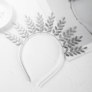 Detailed macro view of vintage silver metal leaf headband with intricate Greek laurel design