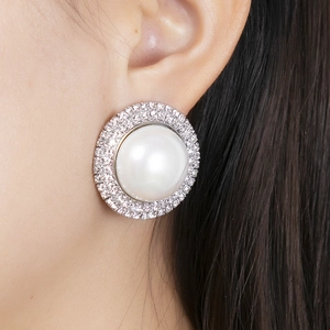 Macro view of luxurious large pearl earring with double-layered sparkling crystal halo