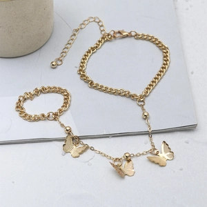 Detail of golden butterfly slave bracelet featuring Cuban links and adjustable lobster clasp