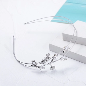 Détail du serre-tête branche en métal argenté orné de perles blanches et d'un motif floral