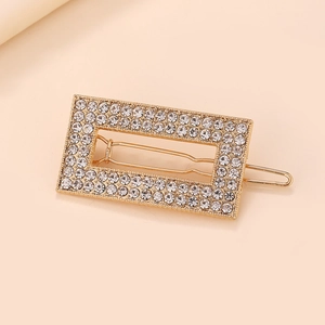 Gros plan détaillé d'une barrette rectangulaire dorée ornée de strass étincelants