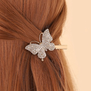 Gros plan d'une barrette papillon en strass étincelante sur des cheveux châtain foncé