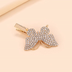 Vue détaillée d'une barrette papillon dorée ornée de strass brillants et étincelants