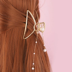 Pince à cheveux élégante en métal doré avec pampilles de perles sur cheveux châtains