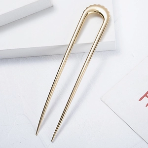 Forcina per capelli minimalista in metallo dorato a forma di U con finitura lucida su pietra