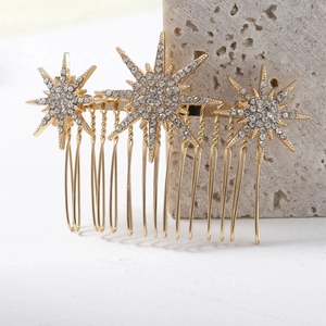 Détail d'un peigne à cheveux doré en forme d'étoile avec strass sur socle en pierre