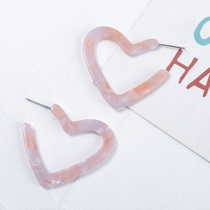 Pink heart-shaped marble resin hoop earrings for women on a white textured background