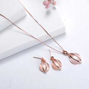 Rose gold necklace and earrings set with pink cat eye stones on a white background