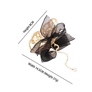 Pince à cheveux élégante en métal doré avec grand nœud en maille noire et gland perlé