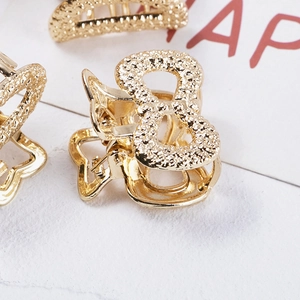 Detail view of mini gold alloy hair claws featuring glitter finish and elegant butterfly shapes
