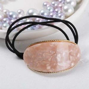 Detailed close-up of pink marble resin hair tie with elegant gold metal frame