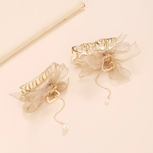 Detail of gold metal hair claws with brown mesh bows and elegant pearl tassels