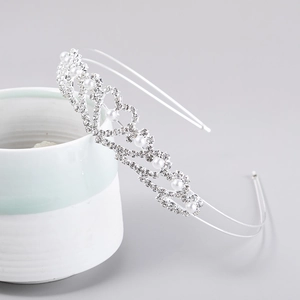 Detailed view of silver bridal tiara featuring hollow heart design with rhinestones and pearls