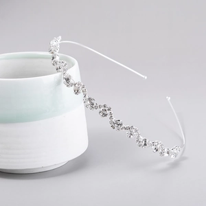 Detailed macro view of wavy silver headband featuring densely inlaid sparkling rhinestones