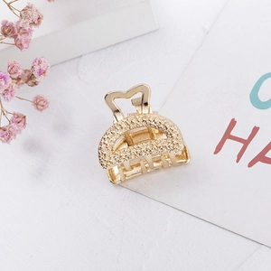Golden mini metal hair claw clip with heart-shaped handle and textured hammer finish
