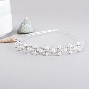 Close-up of bridal headband featuring silver double bands with white pearls and rhinestones