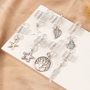 Silver alloy dreadlock jewelry set with various metal pendants on a white geometric stand