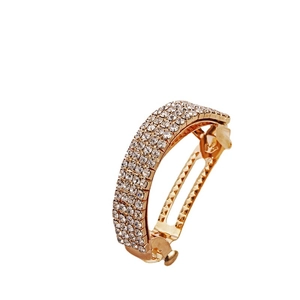 Barrette à cheveux dorée avec quatre rangées de strass étincelants sur fond blanc pur