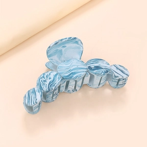 Détail macro de la texture marbre bleu sur la pince à cheveux en acrylique de qualité