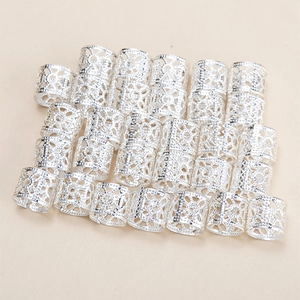 Set of silver hollow dreadlock beads with intricate engraved patterns and metal texture