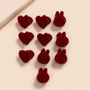 Gros plan d'un lot de 10 barrettes en velours rouge en forme de cœur et de lapin