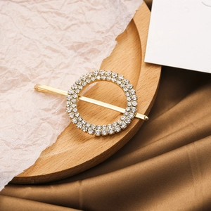 Detail van elegante gouden ronde haarklem met dubbele rij glinsterende strass-steentjes