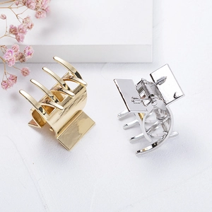 Polished gold and silver metal hair claw clips for high ponytail styling on white background