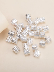 Detailed close-up of vintage silver hollow carved spiral hair rings for dreadlock styling