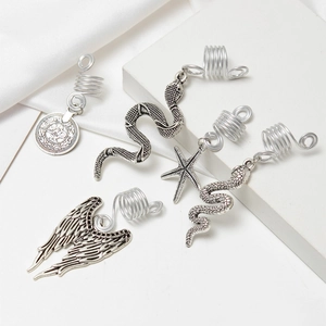 Détail de bijoux de cheveux argentés vintage avec pendentifs d'ailes et de serpent