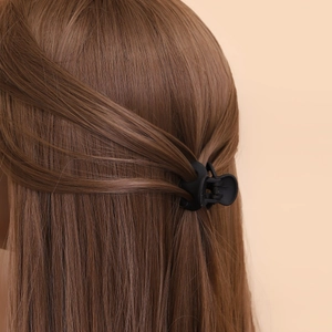 Mini pince à cheveux noire mate pour filles, fixée sur des cheveux bruns bouclés