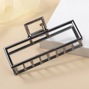 Pince à cheveux élégante en alliage gris fusil avec un design rectangulaire évidé sur beige