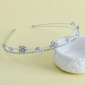 Détail du serre-tête floral en argent avec zircons sur un bol en céramique blanche