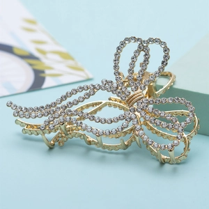 Detail of elegant gold butterfly hair claw with hollow metal wings and crystals
