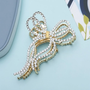 Elegant gold bow hair claw clip with white rhinestones and tassel design for women