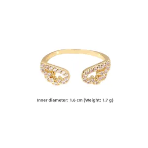 Dettaglio anello dorato con ali e pietre rosa, diametro 1,6 cm e peso di 1,7 grammi