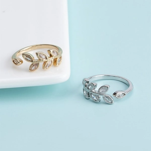 Elegant gold and silver leaf open rings featuring marquise zircon stones on blue background