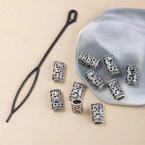 Silver retro hollow dreadlock bead set with intricate patterns and hair threading tool
