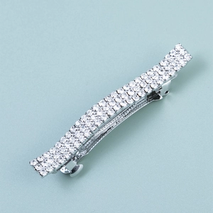 Barrette à cheveux argentée avec trois rangées de strass étincelants sur base incurvée