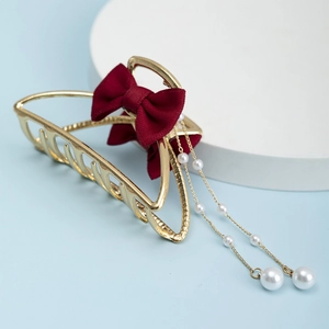 Elegant gold hair claw clip featuring a deep red mesh bow and delicate pearl tassels