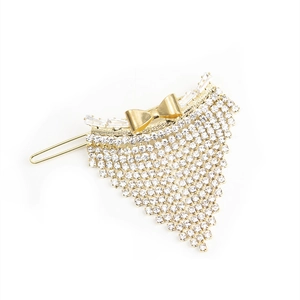 Barrette à cheveux nœud doré avec franges en strass en cascade sur fond blanc