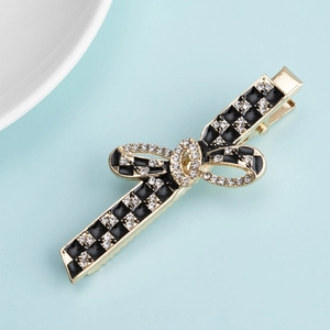 Detailed macro view of the golden metal hair clip with rhinestones and black checkerboard