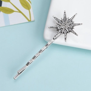 Macro shot of silver wave hair pin with crystal encrusted star and shining details