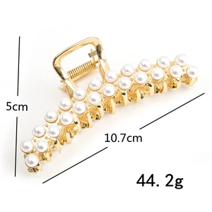 Detail showing dimensions of a gold metal hair claw clip with elegant faux pearls