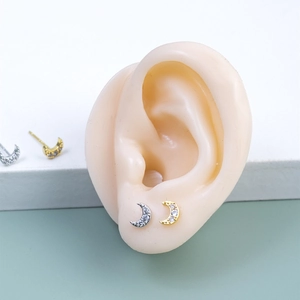 Macro shot of s925 silver moon stud earrings with white zirconia on silicone ear model