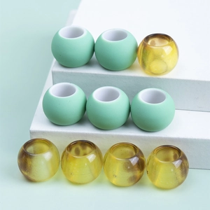 Detail of colorful matte mint green and amber speckled large hole beads for hair jewelry