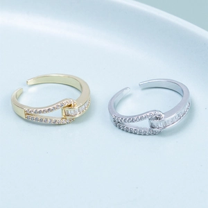 Detail of interlocking buckle ring with cubic zirconia on a light blue background