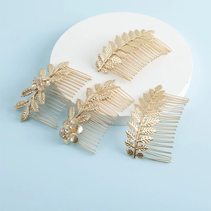 Vue détaillée de peignes à cheveux dorés pour mariée avec feuilles et strass étincelants